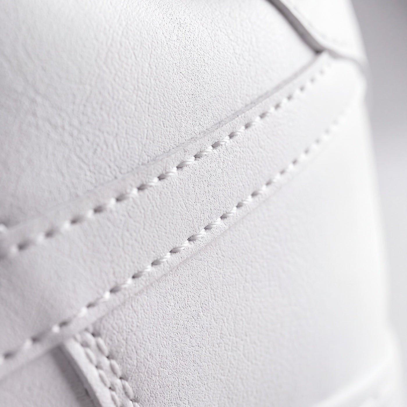 A stitched panel seam on the premium microfiber upper, in close-up.
